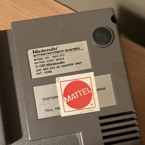 There's a Mattel logo sticker on the Nintendo repair information sticker.