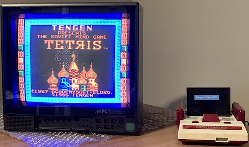 Tengen Tetris is running on the screen next to a Famicom. It says Tengen Presents the Soviet Mind Game: Tetris