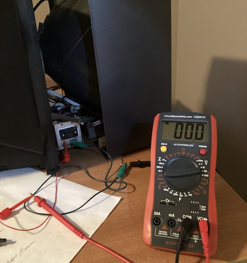 My red Circuit Specialists multimeter is connected to pins 1 and 3 of the STR3115 voltage regulator, and reports zero volts, complaining also of a low battery.