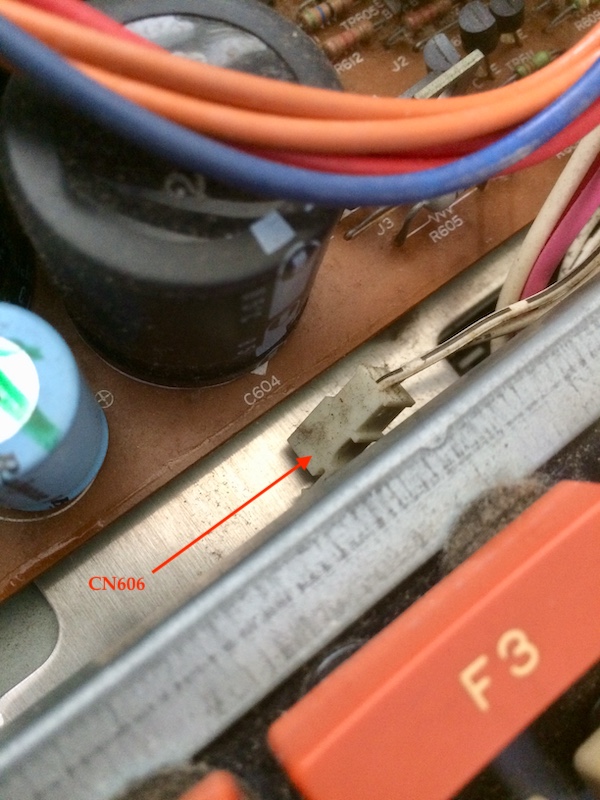 A two-pin connector, a little dirty, sitting loose between the keyboard and the power supply.