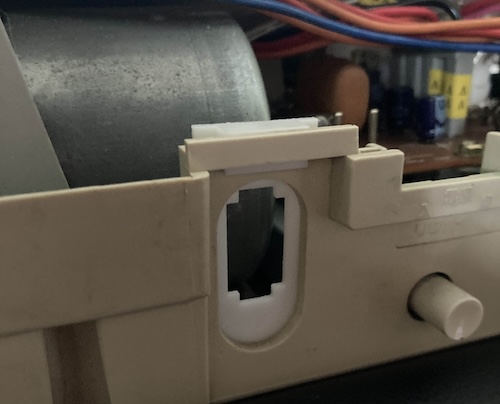 The power bracket is now white plastic, sticking out of the hole in the case.