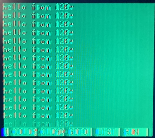 The PC-6001 is running a print/goto loop saying "Hello from 120V" over and over.