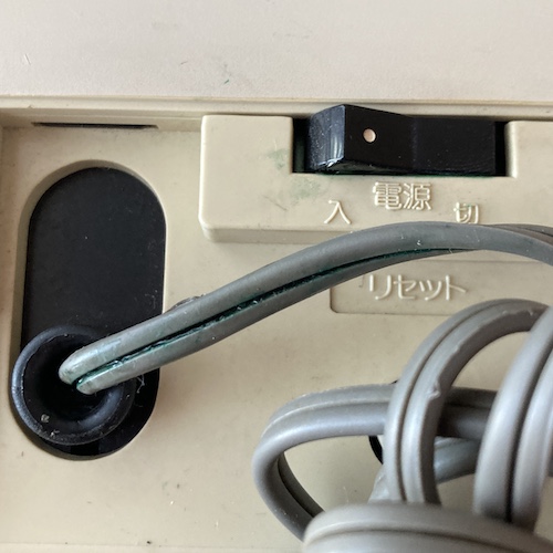 The power cord has become hard, and is leaking green plasticizer which may be reacting with the copper inside the cord. The green goop has spread all over the back of the case and into the power switch as well.