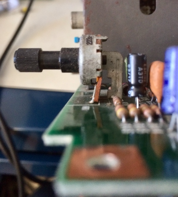 The volume potentiometer from the side. The top half is shifted back quite a bit, breaking the board substrate holding the pot into the motherboard.