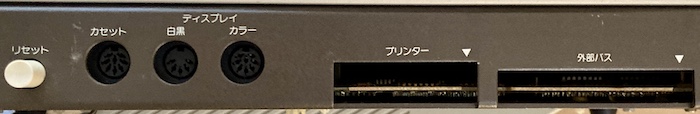 The ports of the computer. From left to right: reset button, cassette DIN, monochrome display DIN, colour display DIN, printer edge, expansion bus edge.