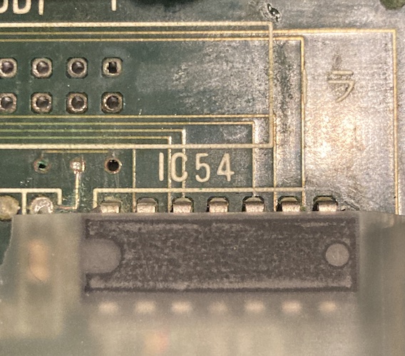 Scotch tape is stuck over the top of IC54, but unfortunately it is not helping expose the label for this IC, which I suspect is a 74.
