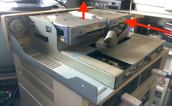 Sliding up the drive brace and sliding out the floppy drives