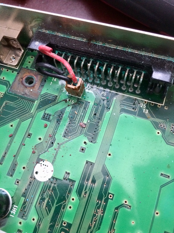 The debris left behind from the leaking backup battery. There is a lot of blue-green corrosion stuck onto the back of the legs that make up the pins of the RS-232 port.