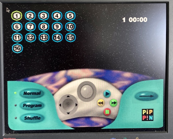 The Pippin's audio CD player interface. It shows the tracks (1 through 16) on the top left, and hovers a Pippin controller over the Earth. An arrow in the lower right chooses between single-play and repeat, and the buttons in the lower left read Normal, Program, and Shuffle