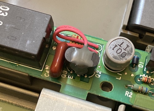 Two transistors are glued together – Q2 and Q3 – with two thick red wires running out at an awkward angle.