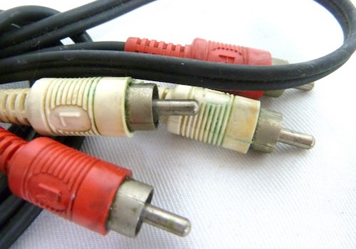 Picture from auction. A set of white and red RCA cables. They are covered with some kind of blue-green slime that is reminiscent of corrosion of copper.