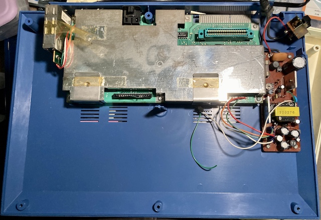 The bottom case of the Pyuuta. The motherboard and power supply together take up less than half of the available space inside the computer.