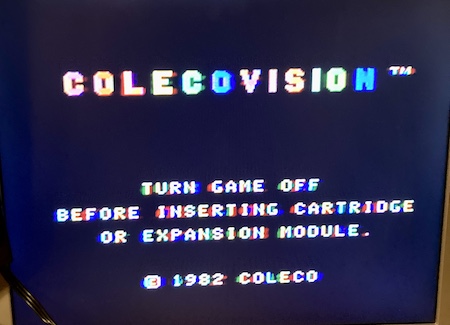 The real ColecoVision is showing the "missing cartridge" BIOS error screen in all its smeary RF glory.