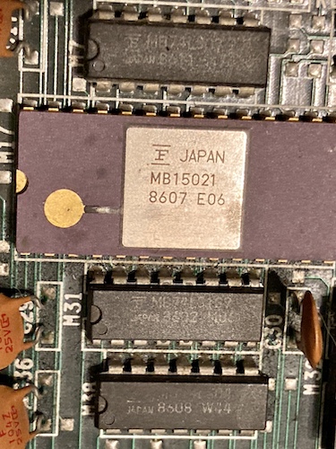 The MB15021 video DAC in its cool, if shopworn, ceramic package. Notice that the "strap" leading to the gold dot on the left side looks rotten, and the silkscreening is damaged on the bottom chip.