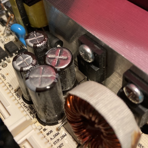 A capacitor has its shrink-wrap label pulled down around its ankles, and is placed worryingly close to a switching transistor.