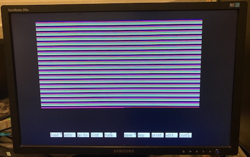 Red, green, magenta, and other colours of lines are being drawn slowly on the monitor.