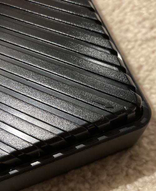 An arrow is cast into the plastic, showing where you should begin prying to lever the back of the monitor off.