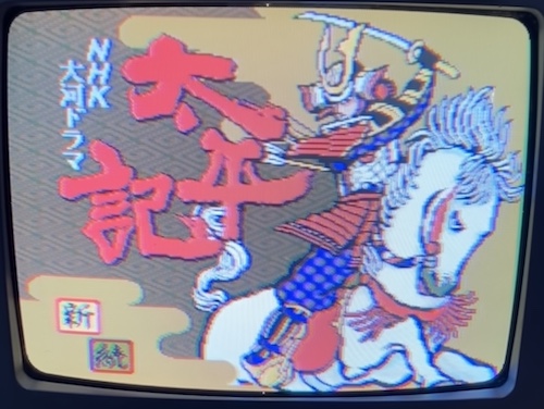 A scary politician on an angry horsey is going to swing his sword at the NHK logo. It looks like he has been shot in the back with some arrows recently, so I guess that might be why everyone is so upset.