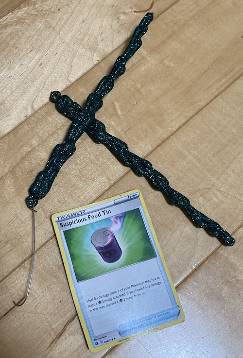 There's two green lumpy sparkly plastic icicles and a "Suspicious Food Tin" Pokemon card on the floor.
