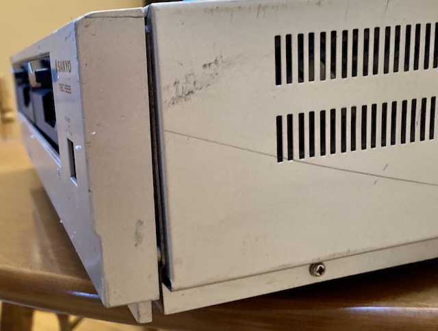 The broken side of the front fascia. You can easily see a crack in the plastic, as well as the misalignment with the floppy drives.