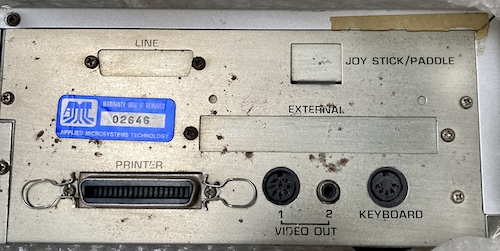 The unpunched blanks for the back of the case. You can also see a blue sticker reading Applied Microsystems Technology, Warranty Void if Removed.