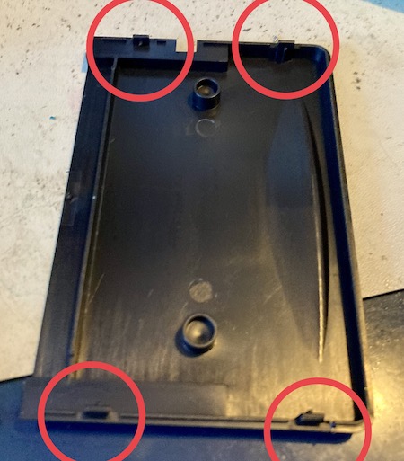 The case is popped open. The four snaps on the back of the case are circled in red.