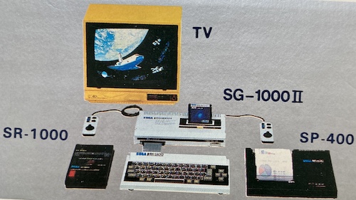 All the parts of the SK-1100, just as Sega wants you to use them. A handsome yellow Victor C-14RX is shown presiding over an SG-1000 II game console (with BASIC inserted,) SR-1000 data recorder, SP-400 plotter printer, and the SK-1100.