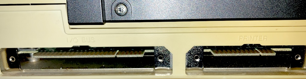 The middle ports: two edge connectors, one marked "I/O BUS," and the other marked "PRINTER," are inside little alcoves in the case.
