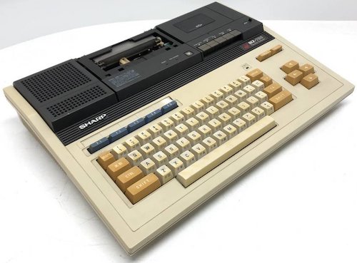 A Sharp MZ-700, from the side. A cover above the keyboard is missing.