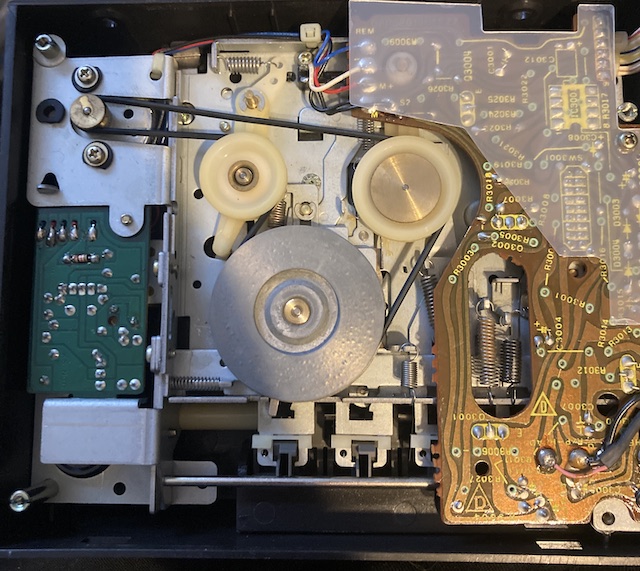 The rear tape belt looks fine, and is wound in an unusual way from the motor, to a pivoting tensioner, to a large spindle, and then onto another idler. I think.