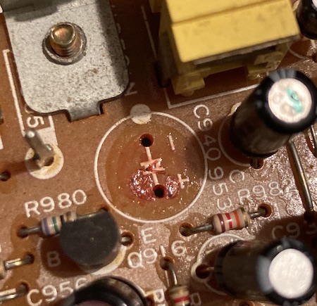 The 470µF capacitor's footprint, covered in some red goop.