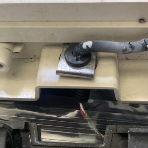 A steel C-clip holds the strain relief of the cable tight against the white top plastic.