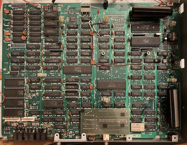 The motherboard is exposed. Pay special attention to the bodges and the covered RF output section. The clock battery is in the top-right of the picture (close to the front of the machine.)