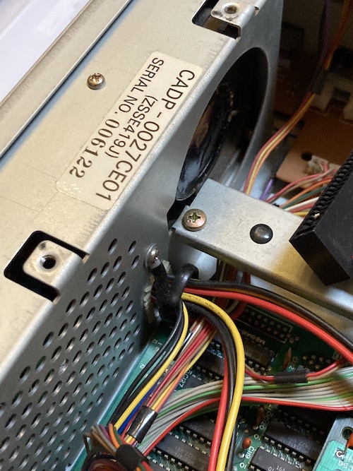The power supply fan is exposed after the bracing is removed. A sticker on the top reads CADP-0027CE01 (ZSSE419J) serial number 006122.