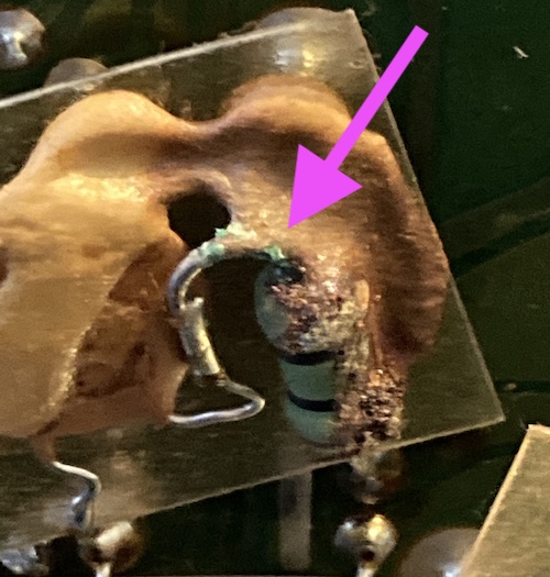 The bodge resistor has some obvious corrosion (called out by a pink arrow) and some ugly solder joints connecting it to what appears to be a ceramic capacitor.