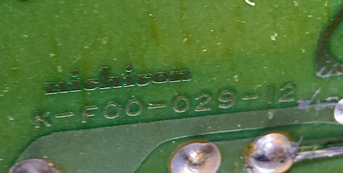 The bottom of the Sharp X1's power supply PCB is marked as Nichicon K-F00-029-12.