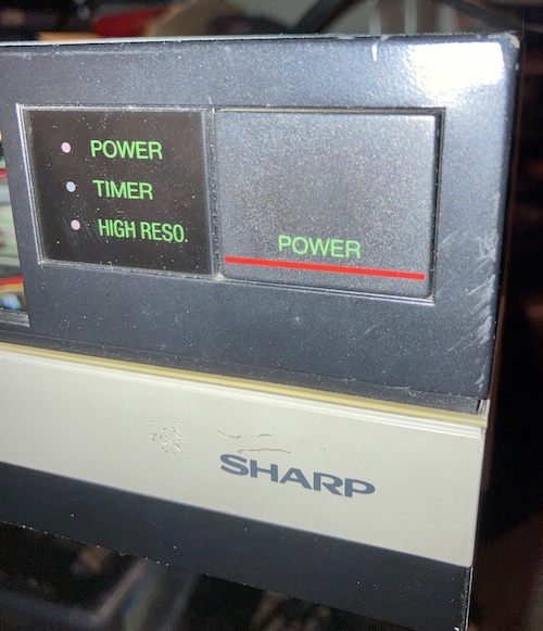 The POWER and HIGH RESO lights are lit on the front of the machine, indicating the computer is working now.