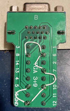 The underside of the breakout connector, with white 30AWG Kynar wires connecting the ground points.