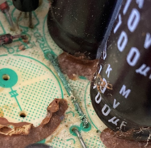 A corroded jumper link in the power supply, with lots of green flakes growing on it.