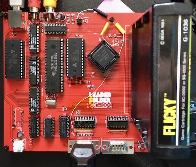 The forum-suggested circuit has been bodged into the board with a fly-wired transistor hanging off the edge. Flicky is loaded into the cart slot.