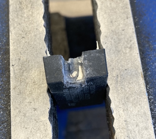 The bulge of the side of the coin cell is emerging, along with a tall vertical pin.