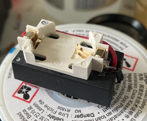 The battery holder is glued on top of the chip, and the red wire goes to the pin closest to pin 13, and the black wire goes to the pin closest to pin 12.