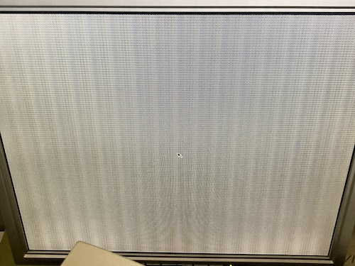 A stippled grey screen, with a mouse cursor on it. This would have been the nice teal OpenWindows splash screen, but I was too slow to catch it.