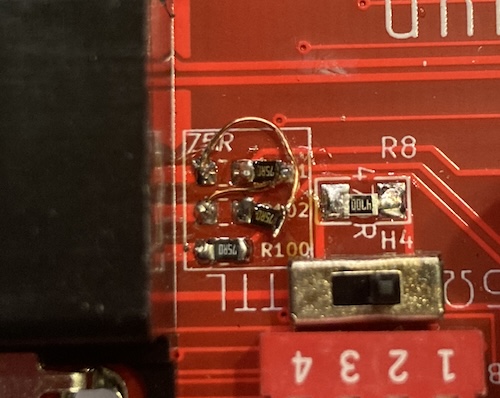 The resistors are pulled away from their pads, with a nasty glob of solder holding each to barely-cleaned magnet wire crossing over.