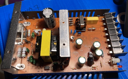 The supply is opened, showing its rather sparse component density and many unpopulated capactor footprints.