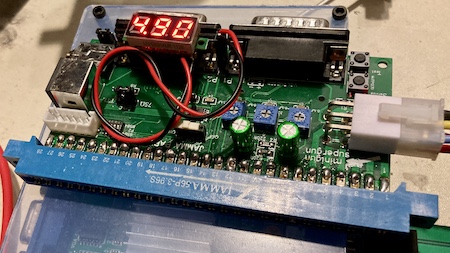 The voltmeter is showing 4.90V on the initial smoke test with the power supply harness.