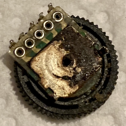 The bottom of the volume pot, after removal from the Supervision. Exposed metal is corroded badly with black-brown scaly rust that has crept inside the pot's main axial "bearing" as well.
