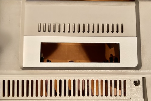 The bracket is significantly whiter than the tan-beige colour of the case plastic surrounding it.