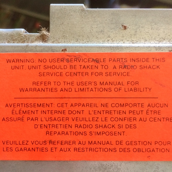 Tandy 1000 power supply warning sticker - unit should be taken to a Radio Shack service centre for service.