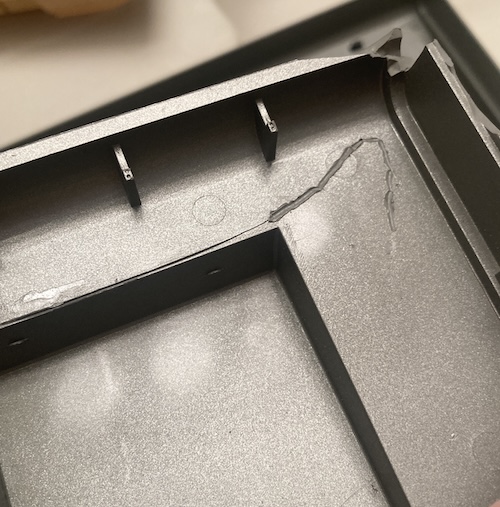 A big gap in the crack has been mended with a crude bead of melted plastic using a soldering iron.